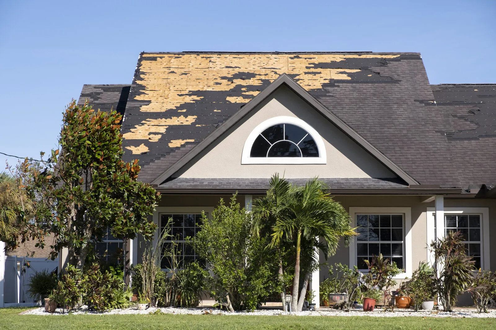 Florida house roof with missing shingles after a storm